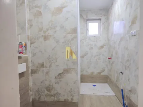 Manje kupatilo sa tuš kabinom obloženo mermernim pločicama. - image 11