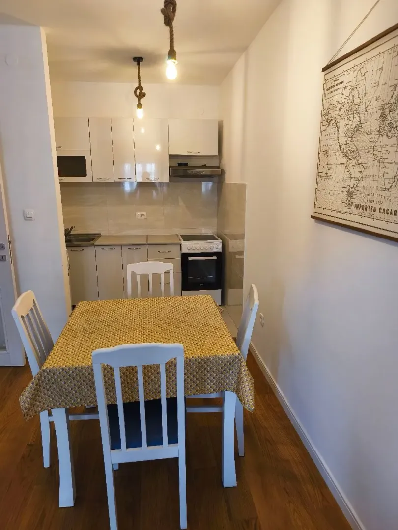 Dining area with a table and chairs and a view of the fitted kitchen.
