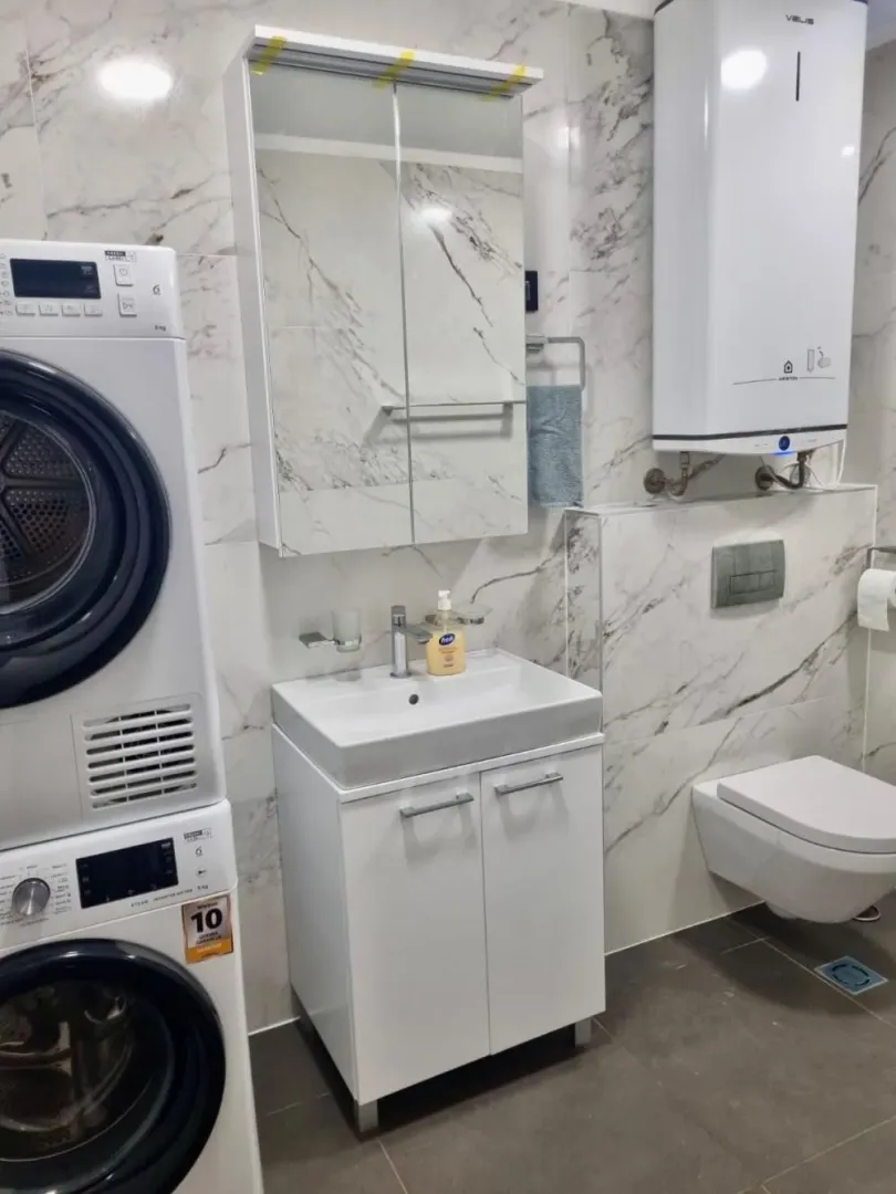 Kupatilo opremljeno umivaonikom, WC šoljom, mašinom za veš i bojlerom.