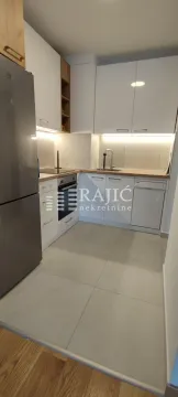 Compact modern kitchen with white cabinetry and built-in appliances. - image 5
