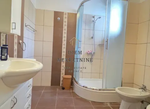Small bathroom with a shower cabin, washbasin, and bidet. - image 4