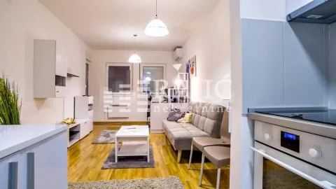 Living room with sofa and dining area connected to the kitchen. - image 3