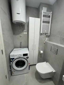 Modernly equipped bathroom with a shower and washing machine. - image 10