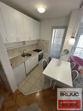 Manja kuhinja sa belim elementima i trpezarijskim stolom. - image 3