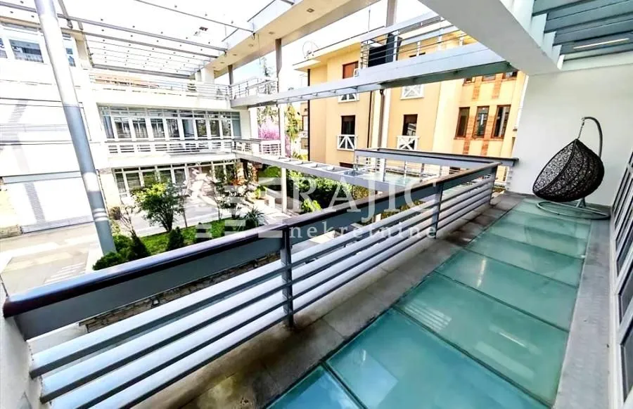 Modern terrace with glass flooring and a view of the building's inner courtyard.