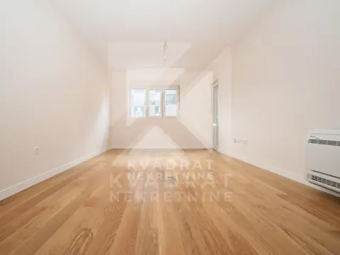 Empty room with wooden flooring and white walls. - image 3