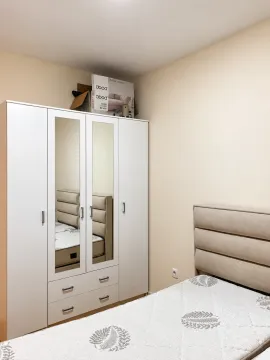 Bedroom with a bed and a white wardrobe with mirrors. - image 4