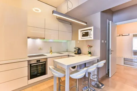 Modern kitchen with a breakfast bar and built-in appliances. - image 3