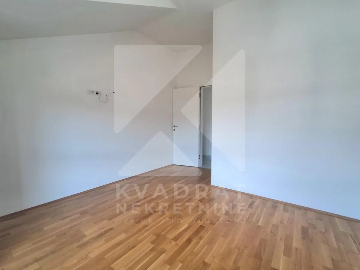 Empty room with hardwood flooring and white walls.