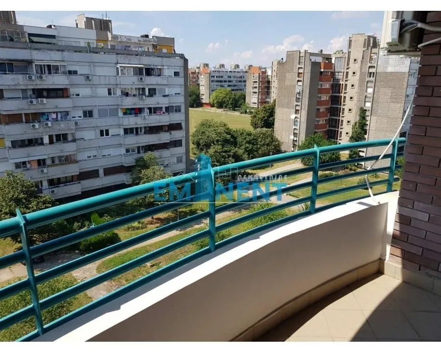 Pogled sa terase na susedne zgrade i zelenu površinu.
