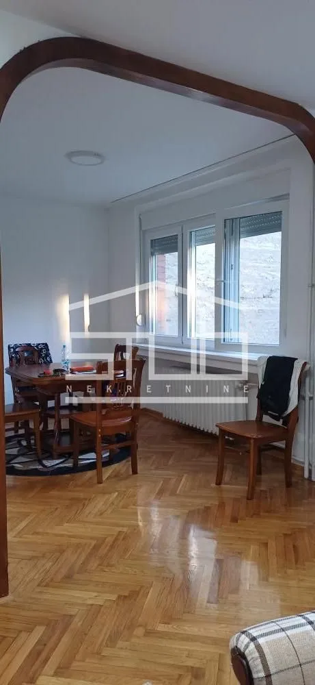 Living room with a dining table and hardwood parquet flooring.