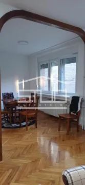 Living room with a dining table and hardwood parquet flooring. - image 2