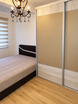 Furnished bedroom with a double bed, large wardrobe, and a chandelier. - image 4