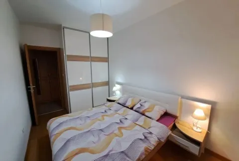 Furnished bedroom with a double bed, wardrobe, and bedside lamps. - image 4