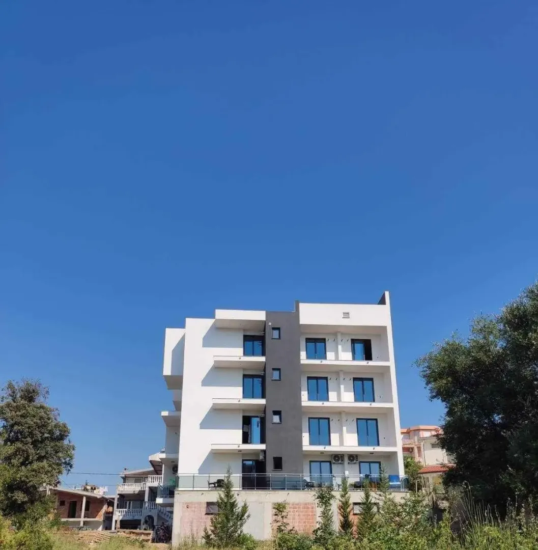 Spoljašnji izgled moderne stambene zgrade sa terasama i balkonskim vratima.