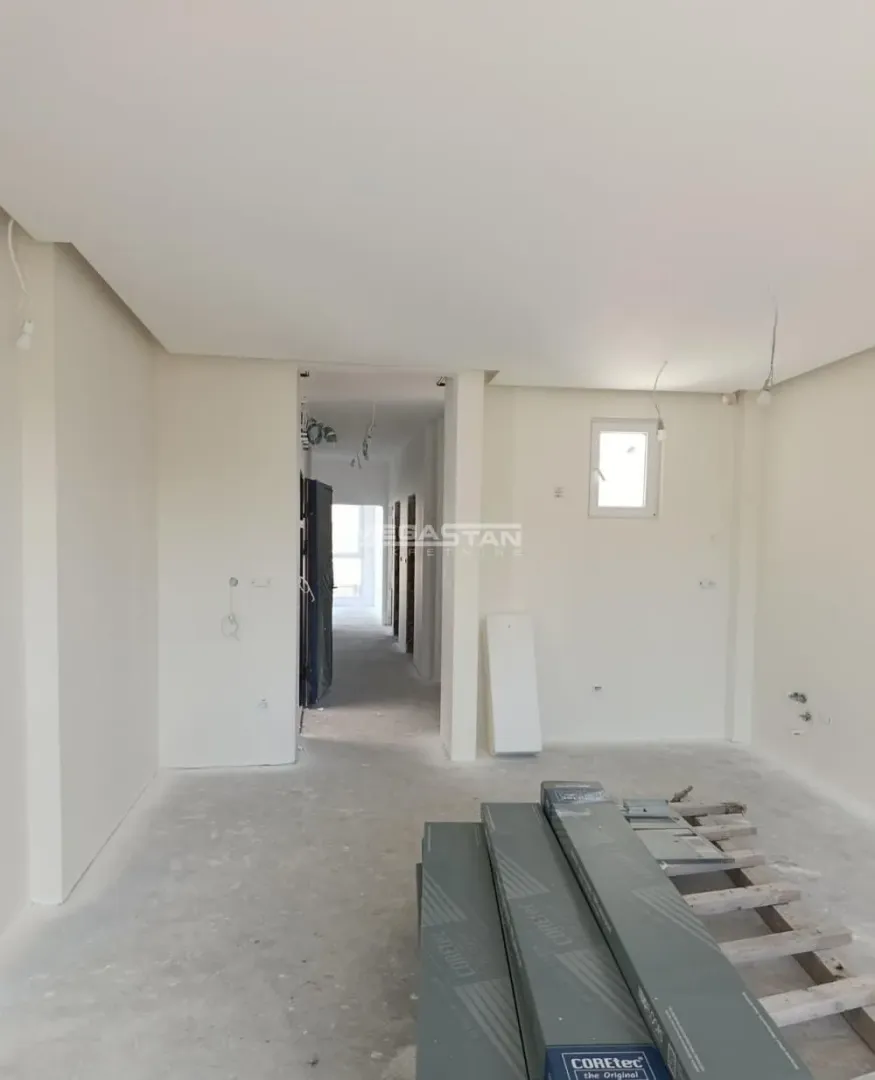 Unutrašnjost nenamestenog stana u završnoj fazi renoviranja sa građevinskim materijalom.