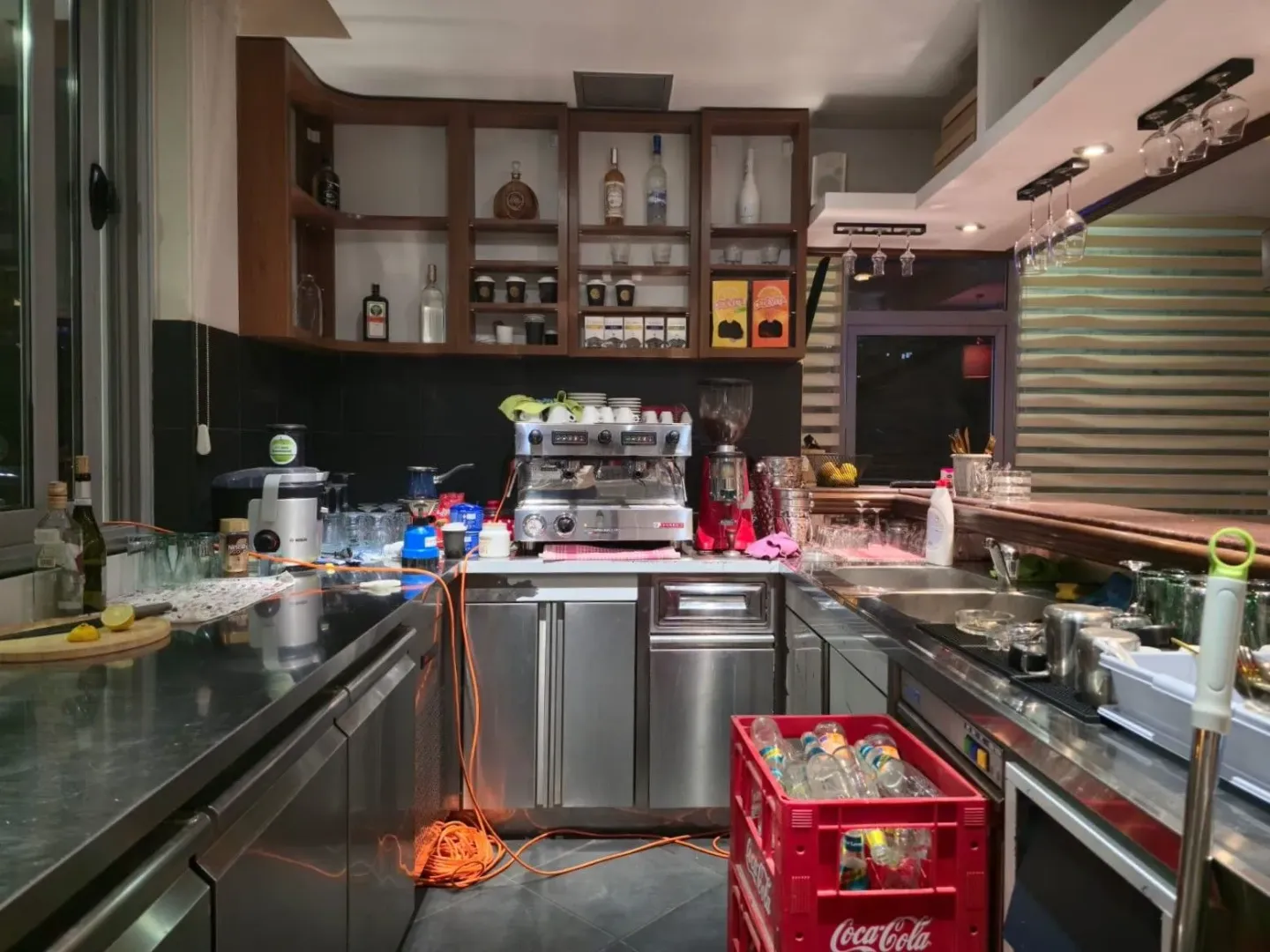 Commercial bar counter with coffee machines and shelving.