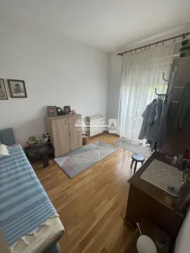 Furnished bedroom with a bed, wardrobe, and balcony access. - image 7