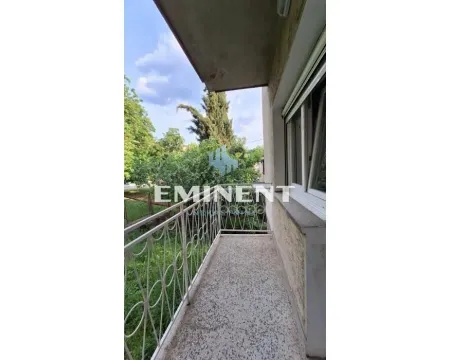 Manji balkon sa metalnom ogradom i pogledom na zelenilo i drveće. - image 9
