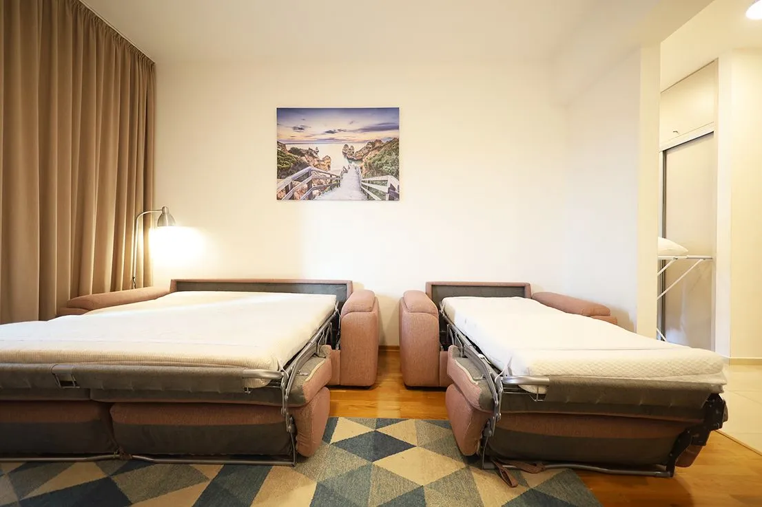 Bedroom with two unfolded sofa beds and a wall painting.