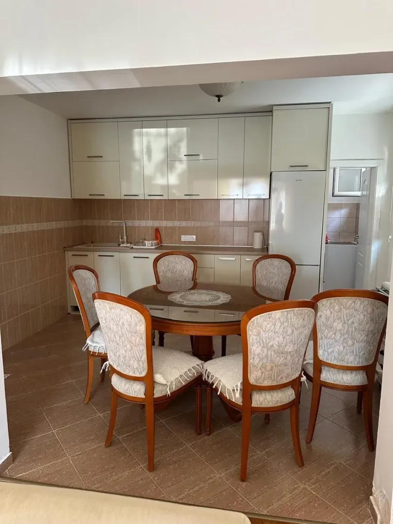 Kitchen with a dining area and a wooden table with chairs.