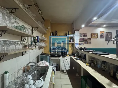 Commercial kitchen with glassware shelves and a bar counter. - image 7