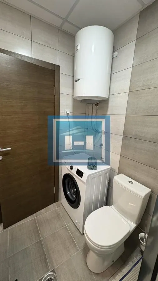 Bathroom equipped with a toilet, washing machine, and wall-mounted water heater.