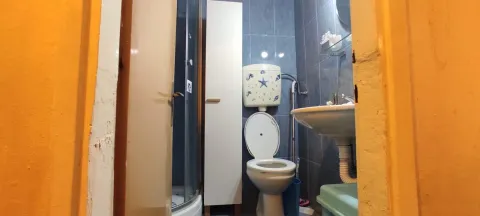 Smaller bathroom with a shower cabin, toilet, and sink. - image 8