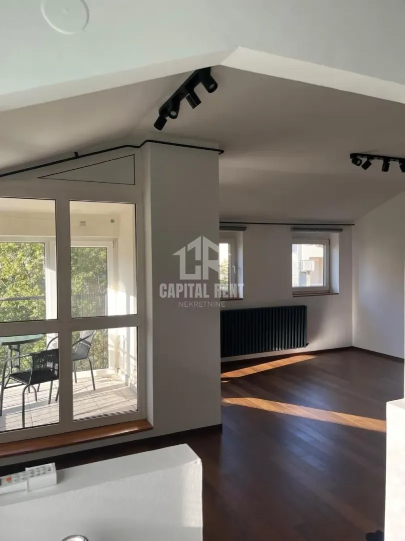 Spacious bright living room with wooden flooring and access to the terrace.