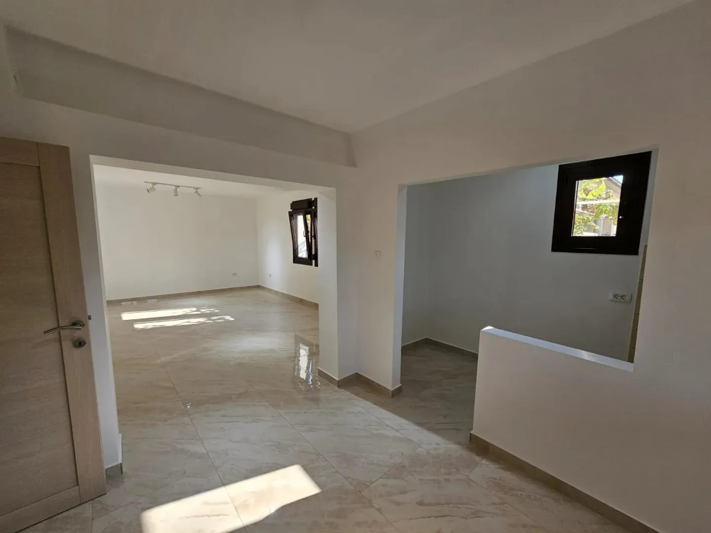 Bright and spacious empty interior with tiled flooring.