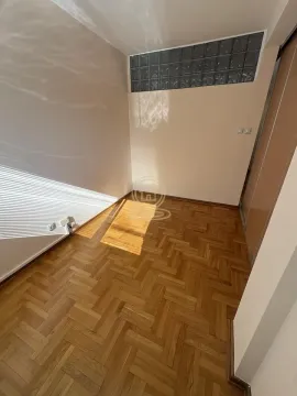 Empty room with parquet flooring and a glass block transom window. - image 10