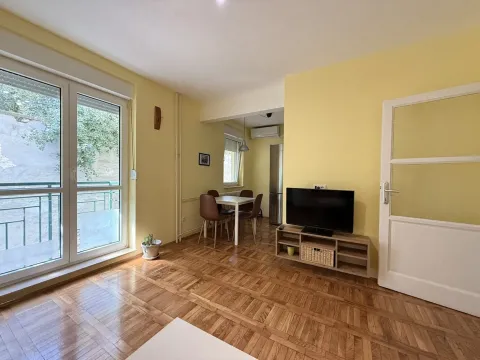 Living room with a TV unit and a dining area in the background. - image 2