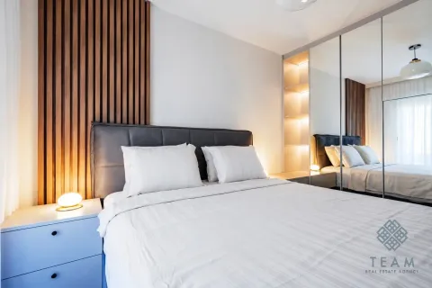 Modern bedroom with a double bed, wooden wall panel, and built-in mirrored wardrobe. - image 8