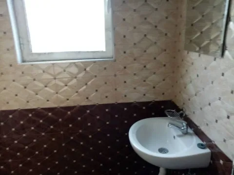 A simple bathroom with wall tiles and a white sink. - image 16
