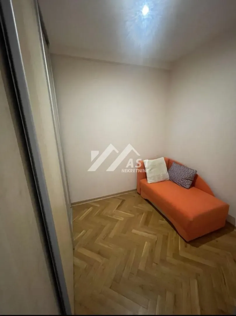 Manja soba sa narandžastim krevetom i ugradnim plakarom.