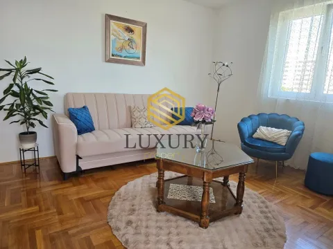 Living room with a sofa, armchair, and coffee table. - image 2