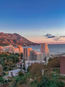 Prelijep pogled na more, planine i višespratnice tokom zalaska sunca. - image 16