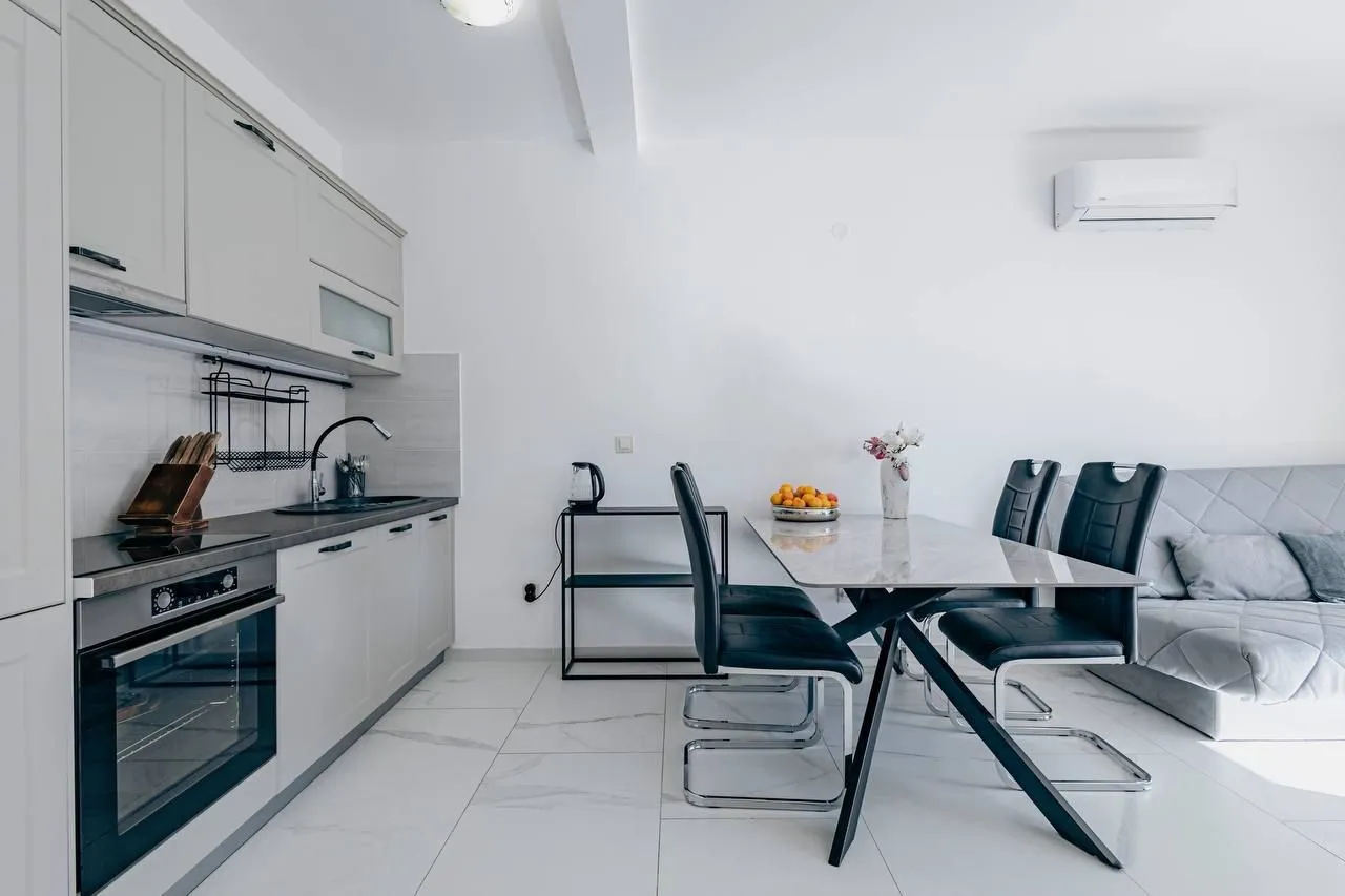 Living room with dining area and kitchen in bright tones.
