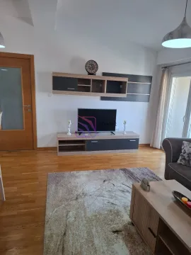 Dnevna soba sa televizorom, namještajem i drvenim podom. - image 3