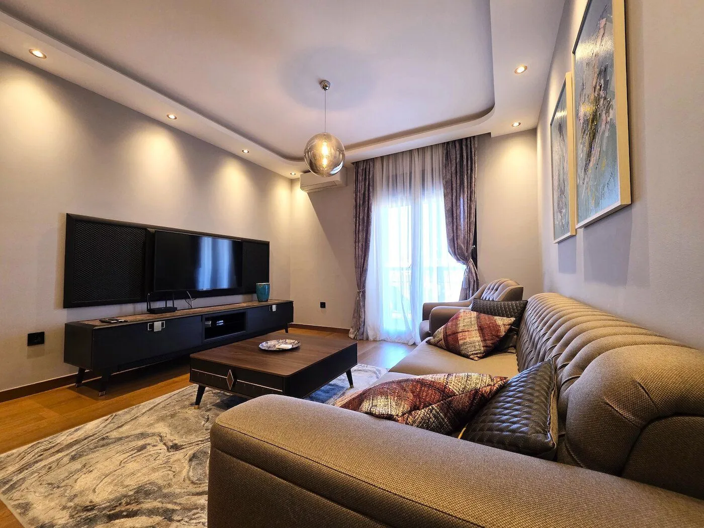 Modern and bright living room with a sofa set and TV unit.