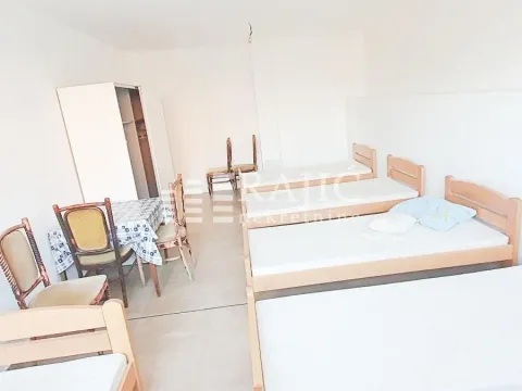 Bedroom with multiple beds and a wardrobe. - image 2
