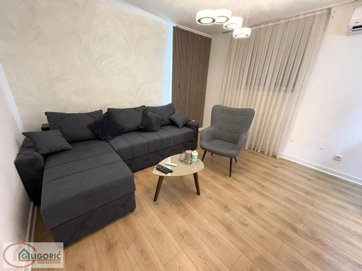 Living room with a grey sectional sofa, armchair, and a coffee table.