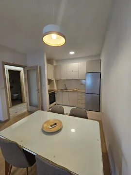 Dining area with a dining table and a kitchen in the background. - image 4