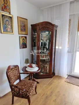 Dnevna soba sa drvenom vitrinom, foteljom i ikonama na zidu. - image 4