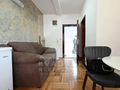 Smaller living room with a brown sofa, dining table, and parquet flooring. - image 13