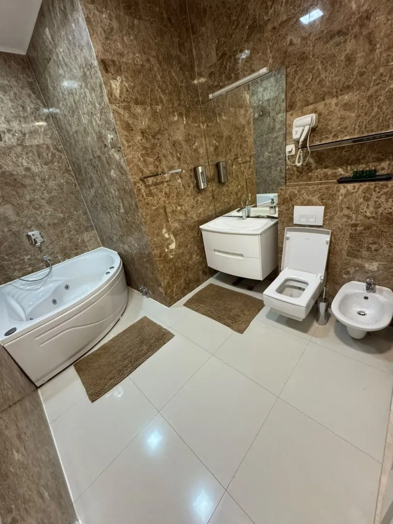 Bathroom equipped with a hydromassage bathtub, vanity sink, toilet, and bidet.