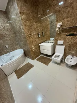 Bathroom equipped with a hydromassage bathtub, vanity sink, toilet, and bidet. - image 15