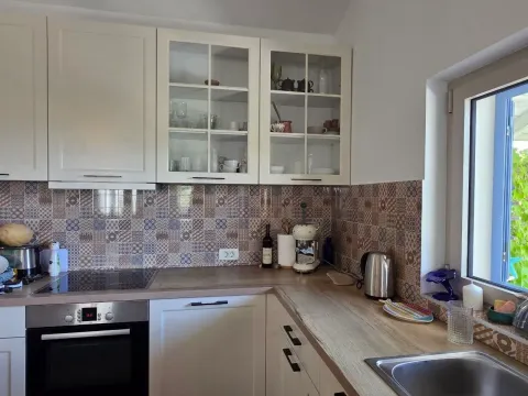 Manja kuhinja sa bijelim elementima, šarenim keramičkim pločicama i ugradnim aparatima. - image 3