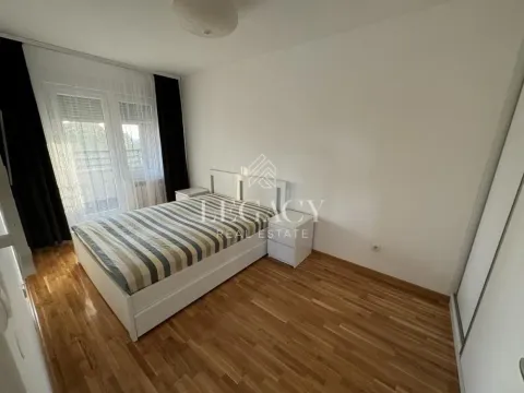 Nameštena spavaća soba sa bračnim krevetom, noćnim stočićima i prozorom sa zavesama. - image 5