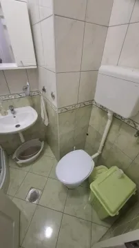 Manje kupatilo sa umivaonikom i toaletom obloženo keramičkim pločicama. - image 9
